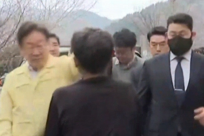 27일 경북 영양군 이재민 대피소 인근에서 검은 옷을 입은 남성이 이재명 더불어민주당 대표를 향해 옷을 휘두르는 모습. [사진출처 = MBN]